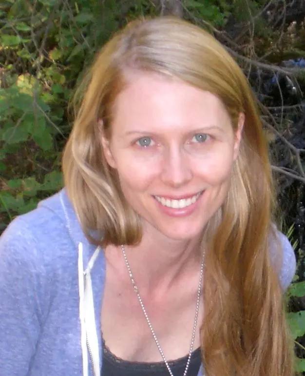 A woman with long blonde hair smiling for the camera.